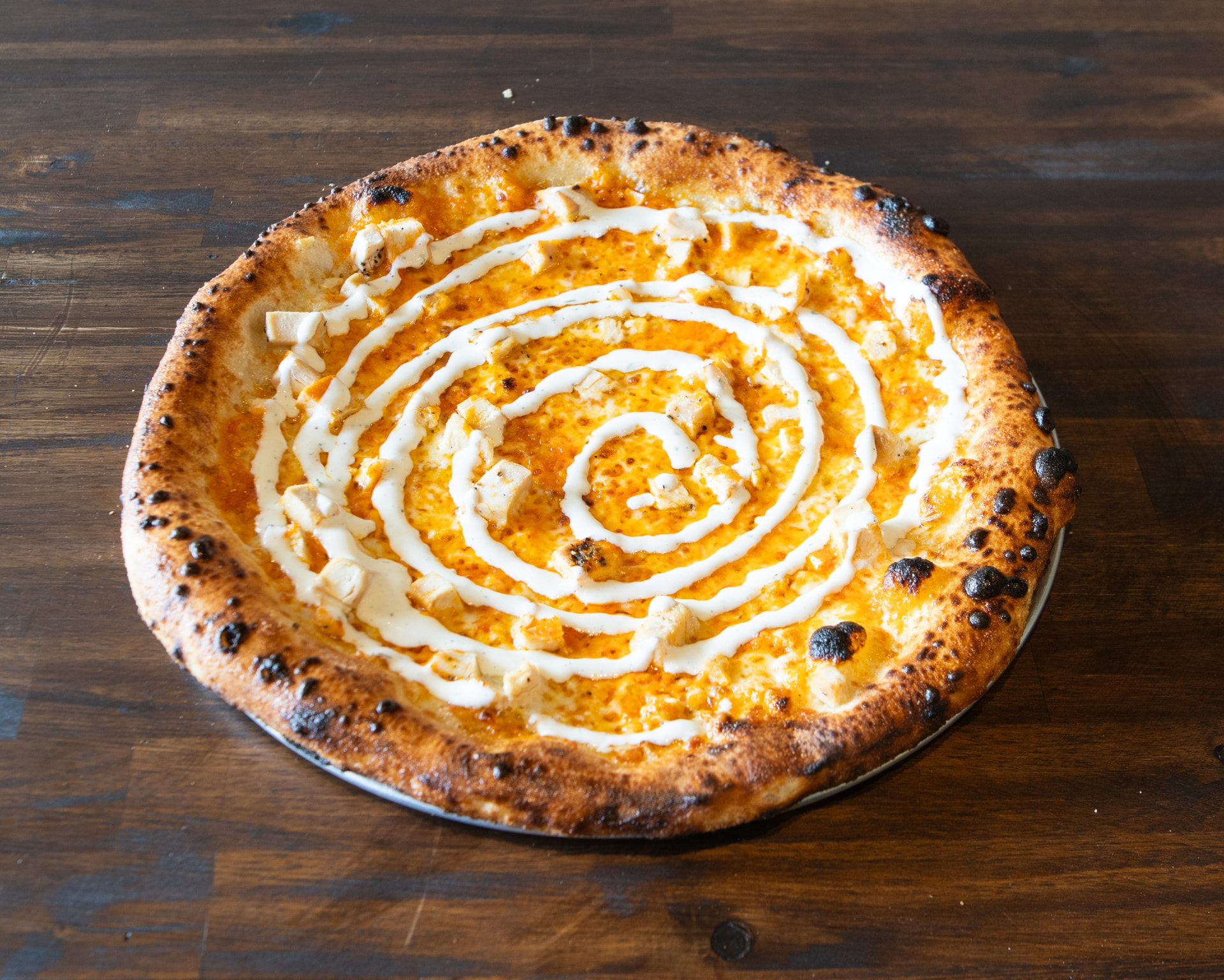 Calabrian buffalo chicken pizza with ranch drizzle