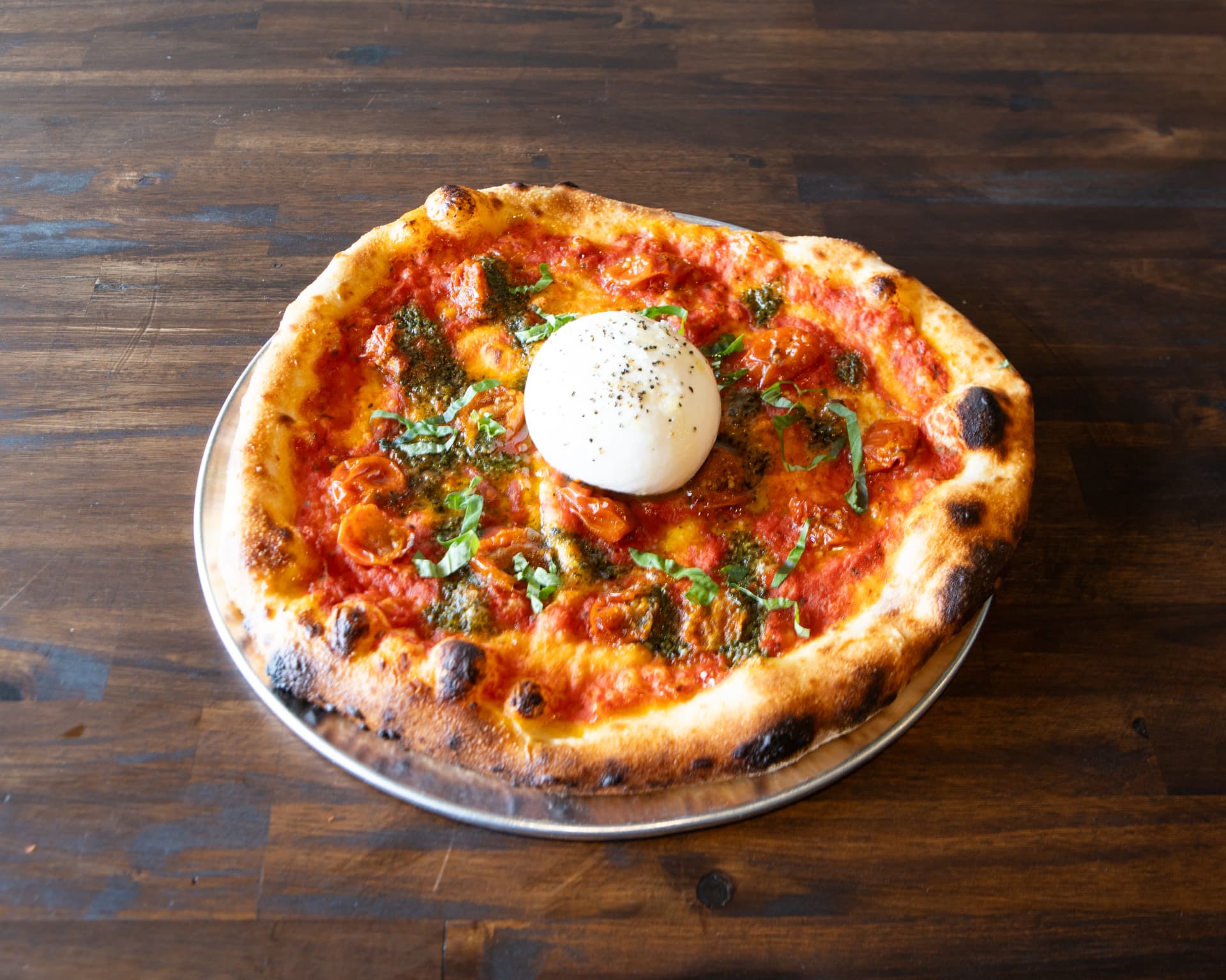 Burrata pizza with roasted cherry tomatoes, pesto and fresh basil