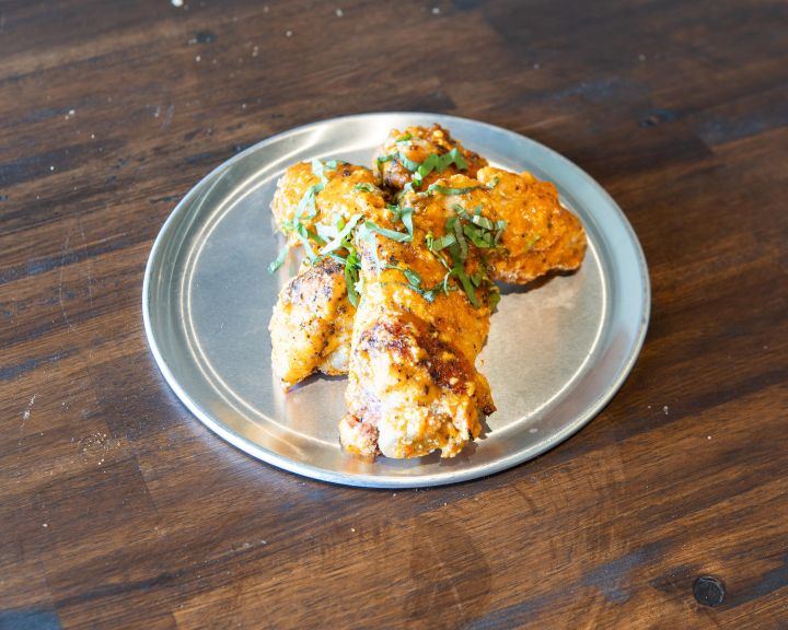 Paseo wings with Calabrian chili sauce, Parmesan and fresh herbs