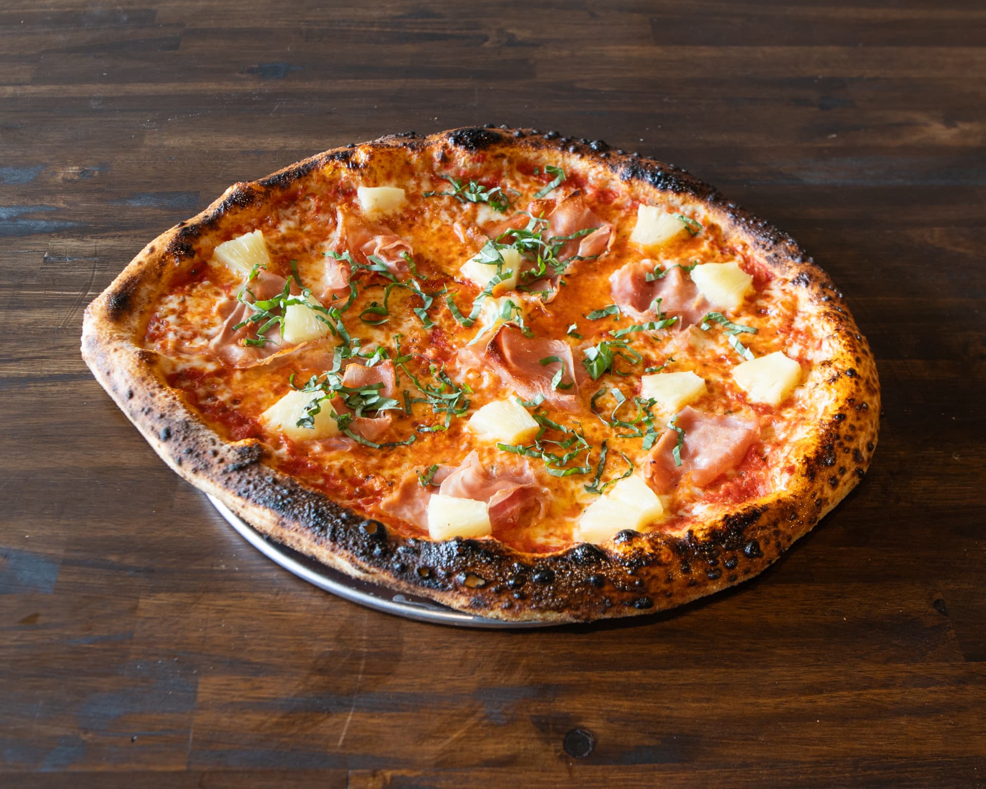 Hawaiian pizza with prosciutto cotto, roasted pineapple and fresh basil