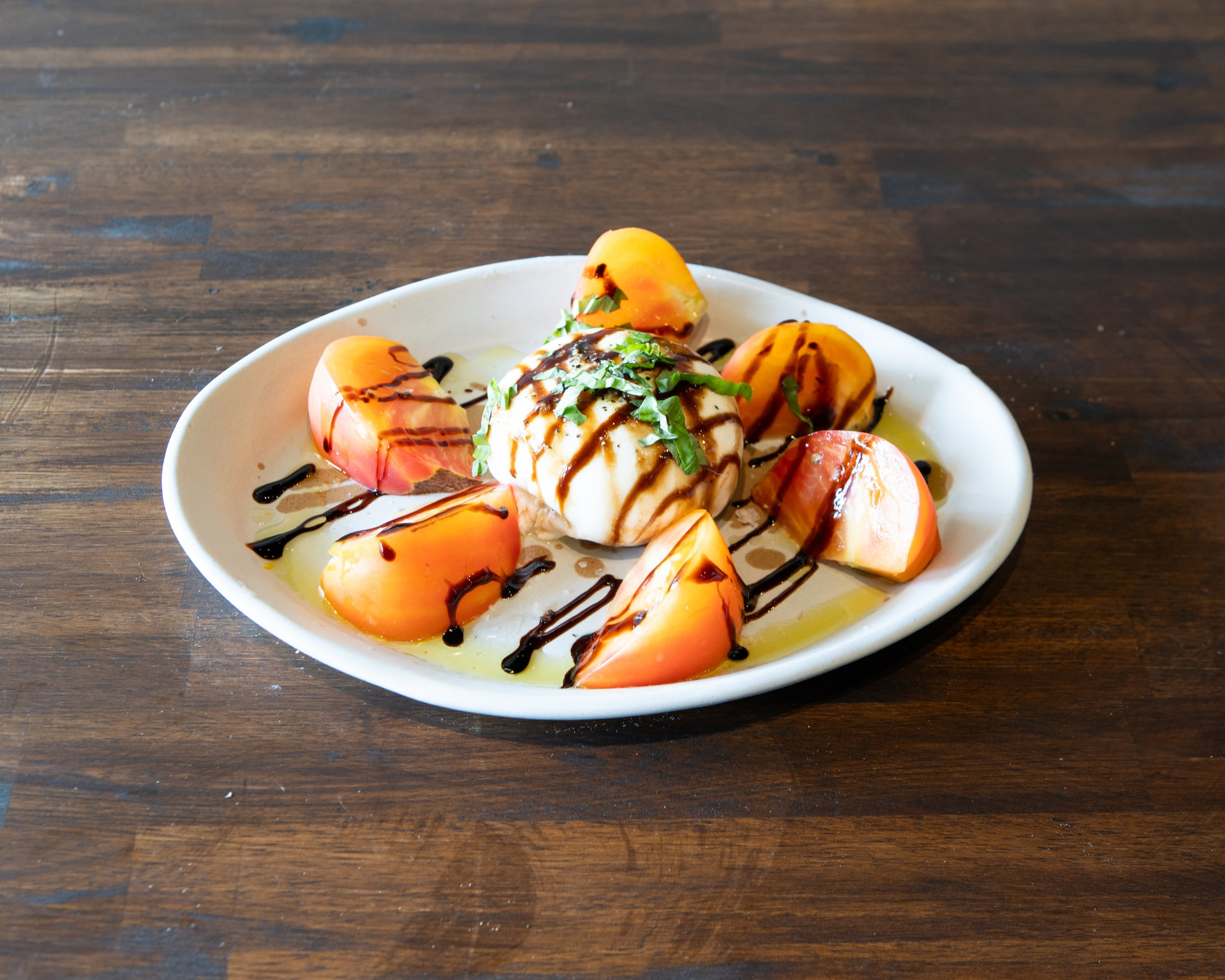 Seasonal Italian burrata with heirloom tomatoes, basil and balsamic